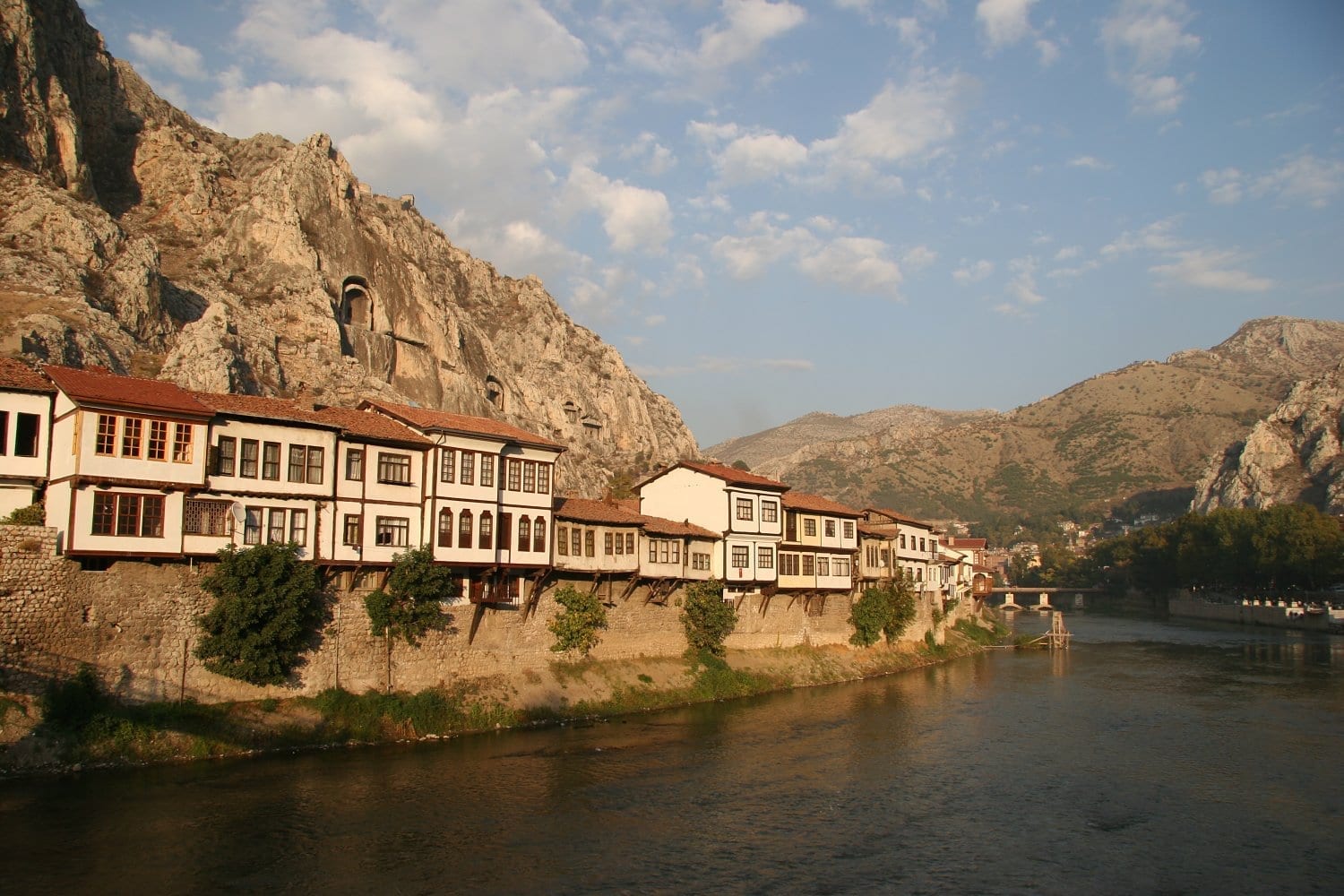 Las casas tradicionales de Amasya, a orillas del río, respaldadas por antiguas tumbas de roca Amasya Turquía