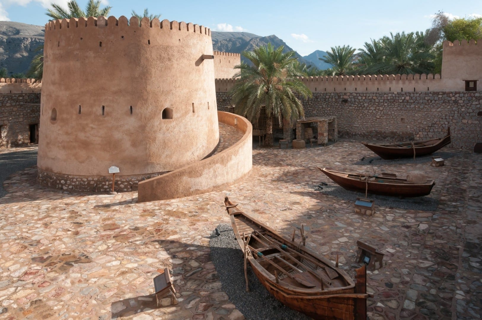 Patio central del Castillo de Khasab con barcos de pesca tradicionales en exhibición Khasab Omán