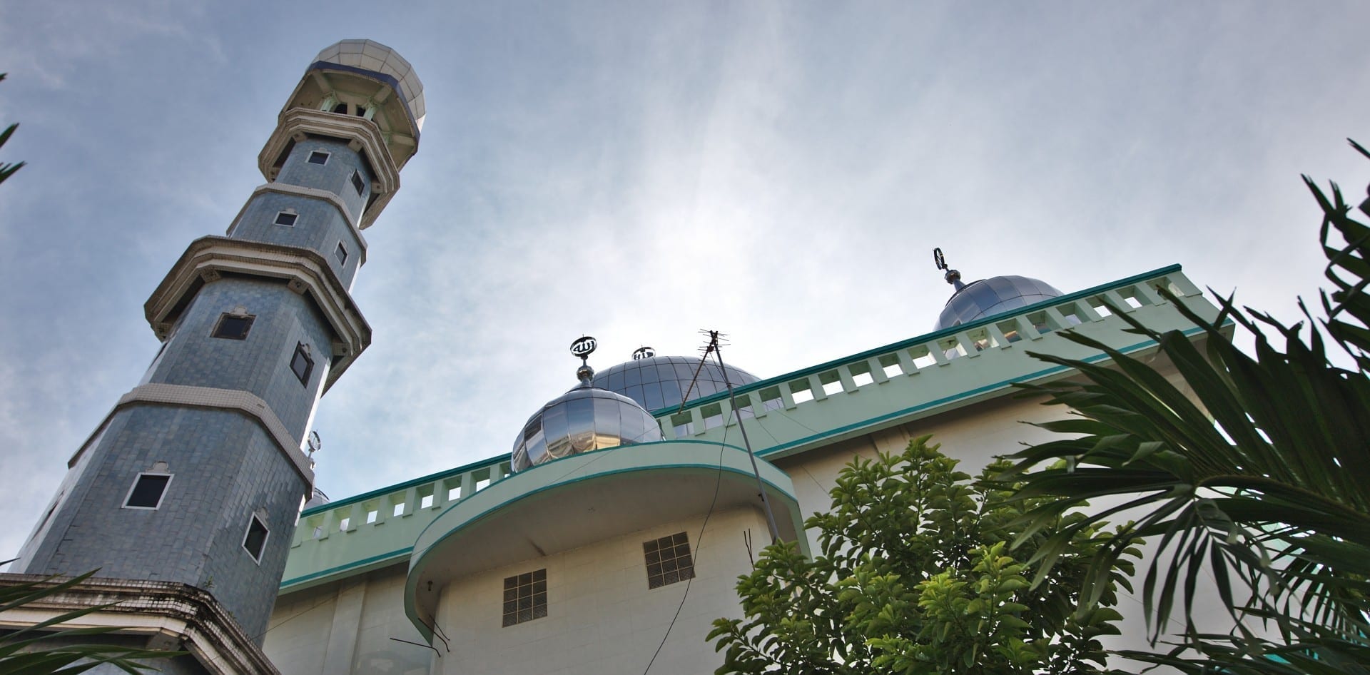 Una de las numerosas mezquitas de Medan, con minarete de azulejos y cúpulas visibles. Medan Indonesia
