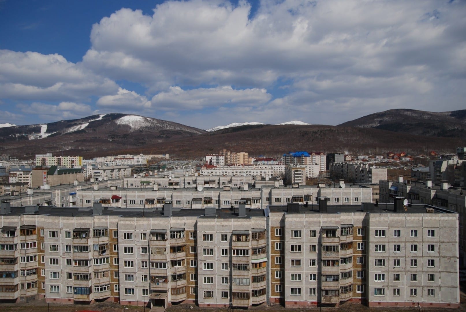El paisaje típico de Yuzhno-Sakhalinsk: edificios de estilo soviético y montañas pintorescas Yuzhno-Sajalinsk Rusia